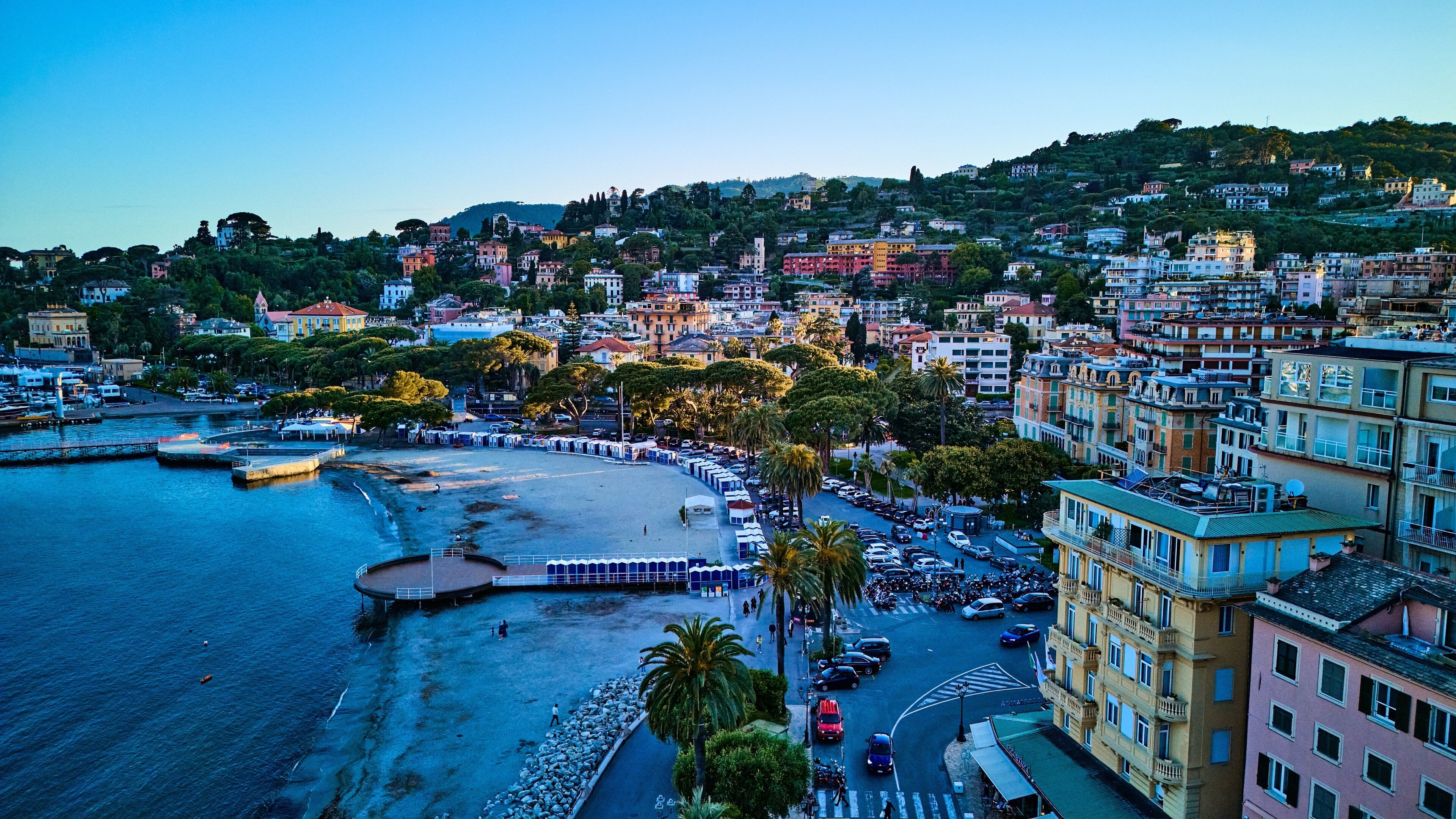A coastal town with a marina, a beach, and colorful buildings.