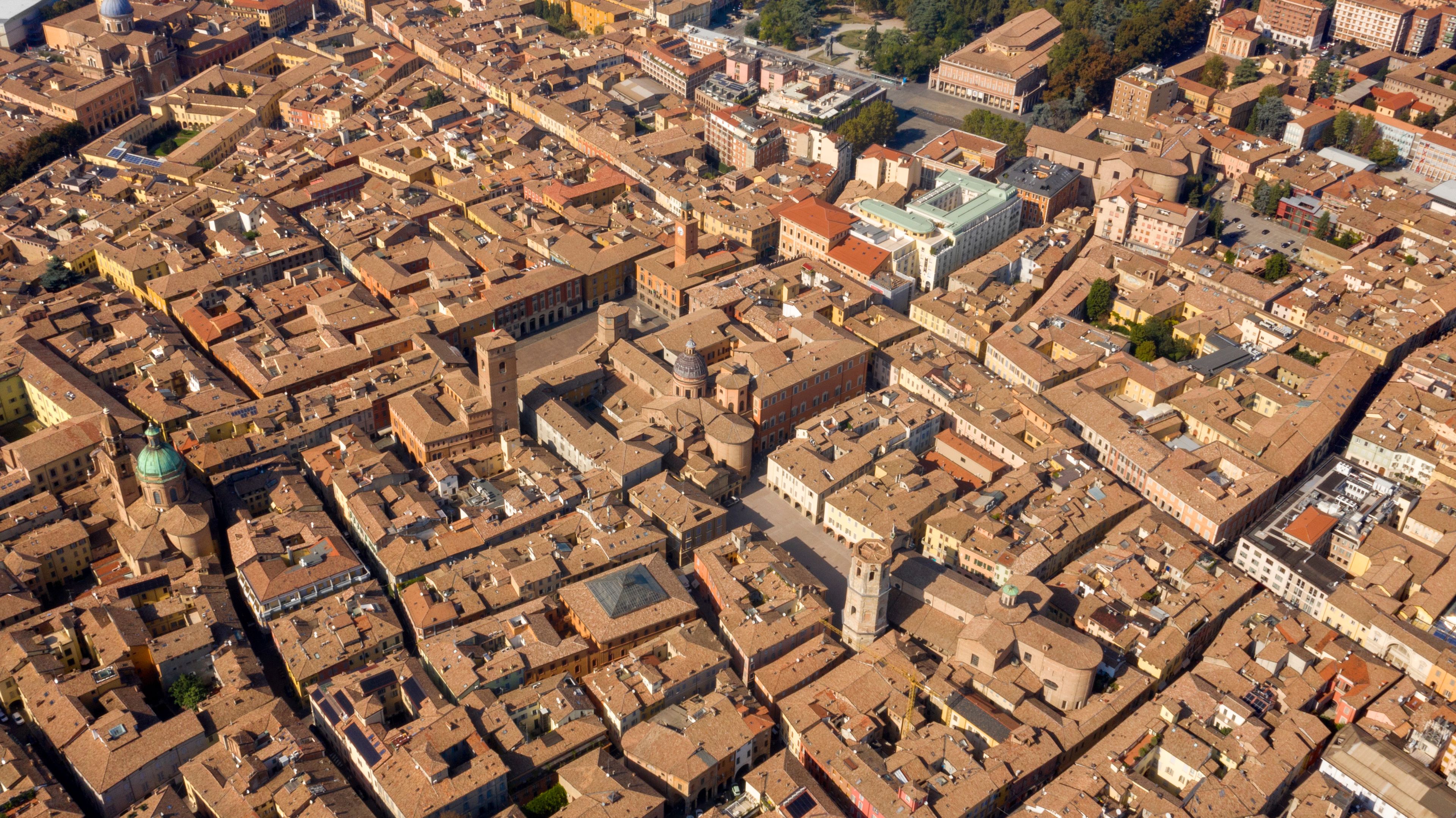 An aerial view of a densely packed urban area with historic architecture, including domed buildings and towers.