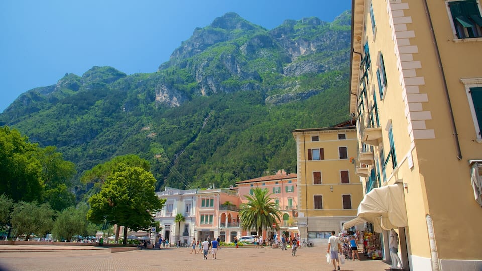 A square with people walking, buildings, and a mountain in the background.