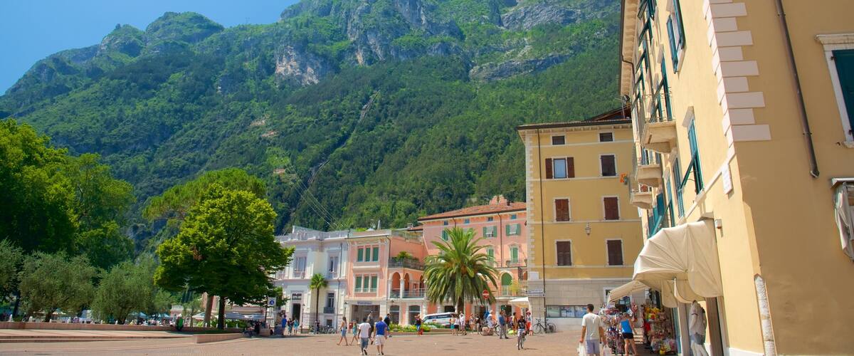 A square with people walking, buildings, and a mountain in the background.