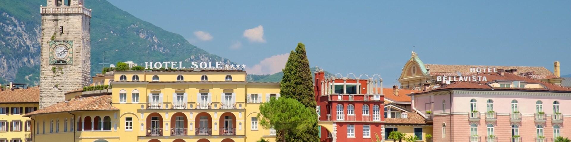 Un pueblo costero con una destacada torre del reloj, Hotel Sole y Hotel Bellavista.