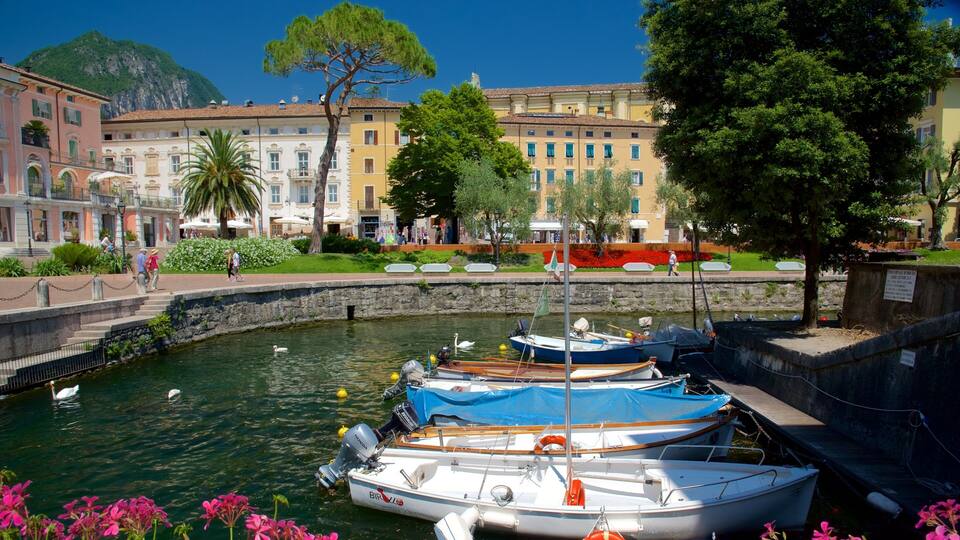 A canal with boats, a stone wall, and buildings in the background.
