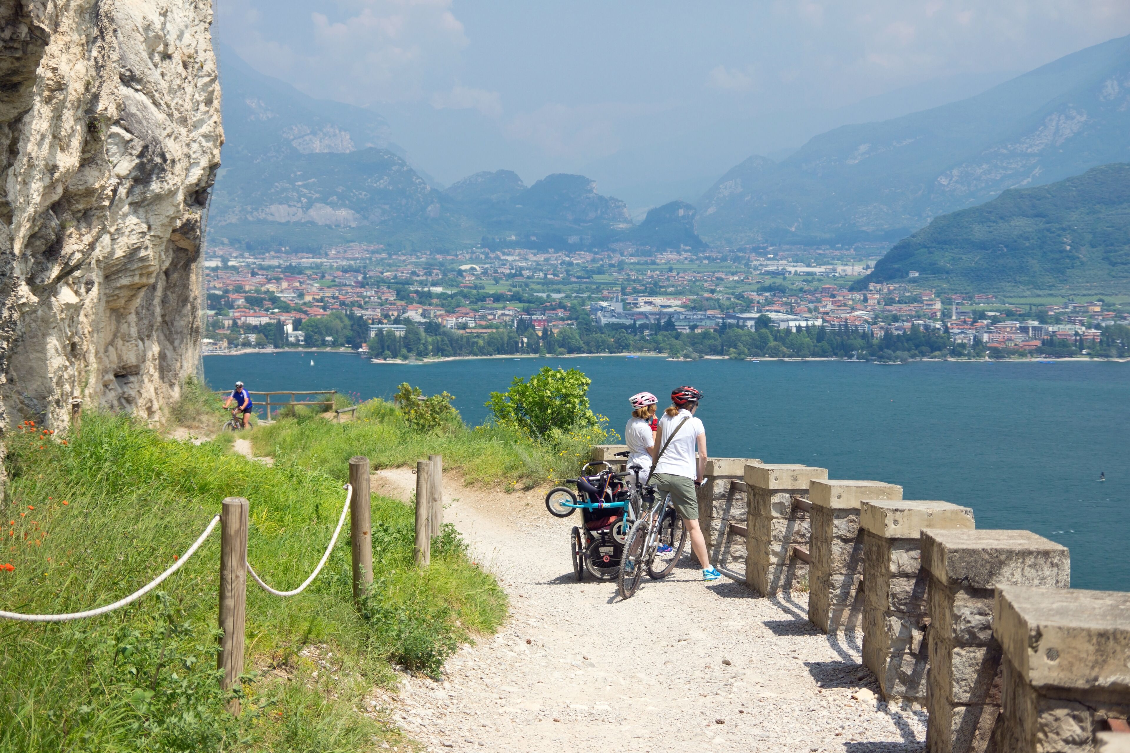 A coastal path with a view of a town and mountains in the background.