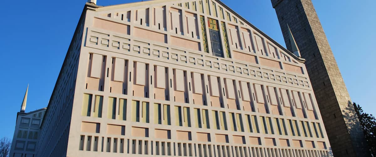 A modern building with a geometric facade and two spires.
