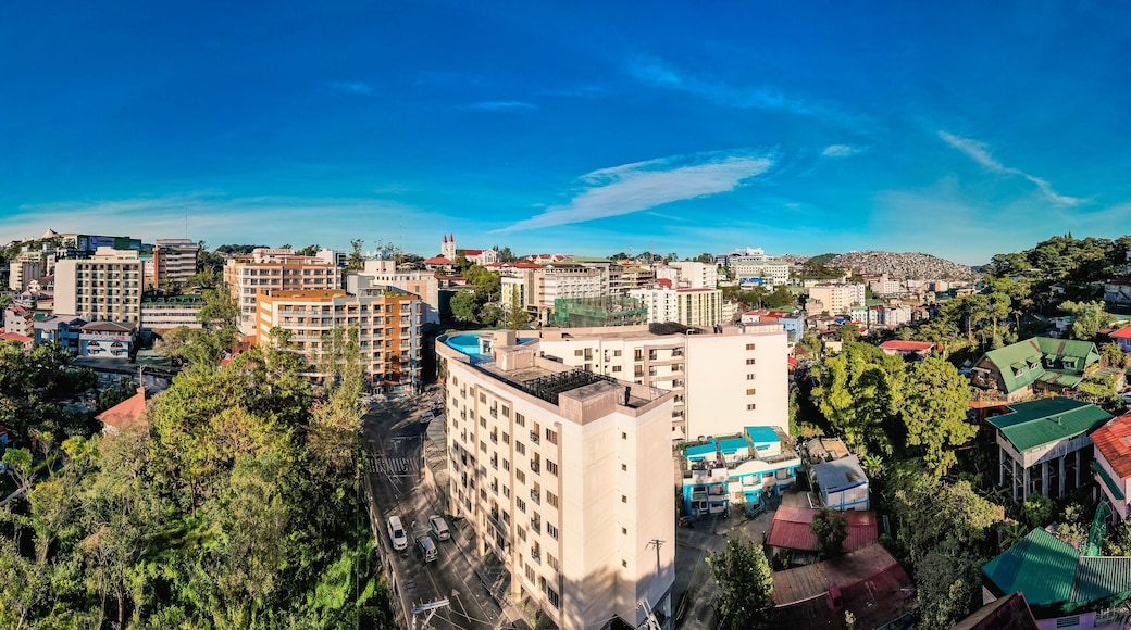 Baguio City, Philippines - Jan 16, 2024: Panoramic aerial of Midrise condominium buildings and Happy Glenn Loop near the core dowtown area at morning.