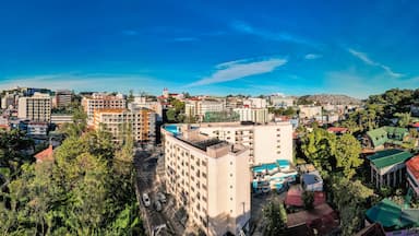 Baguio City, Philippines - Jan 16, 2024: Panoramic aerial of Midrise condominium buildings and Happy Glenn Loop near the core dowtown area at morning.