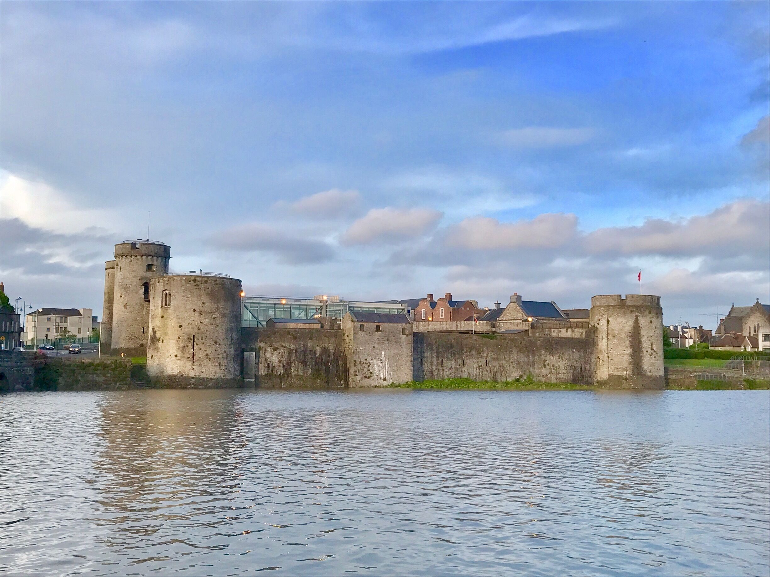 A historic stone castle with a moat and a bridge in the background.