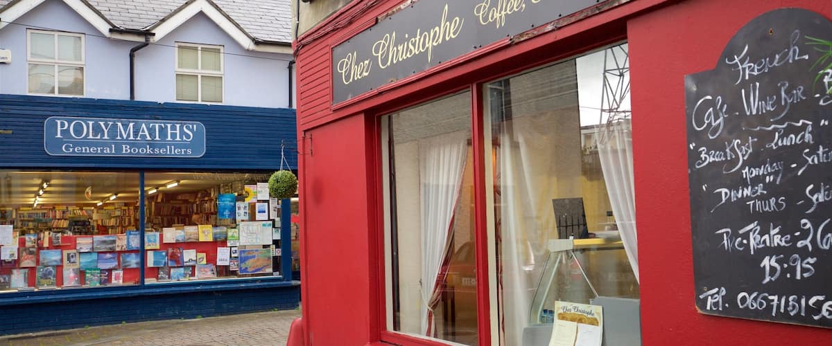 A red storefront with a sign for 'Chez Christophe Coffee, Eatery & Wine Bar' and a chalkboard menu listing breakfast, lunch, dinner, and prix fixe options.
