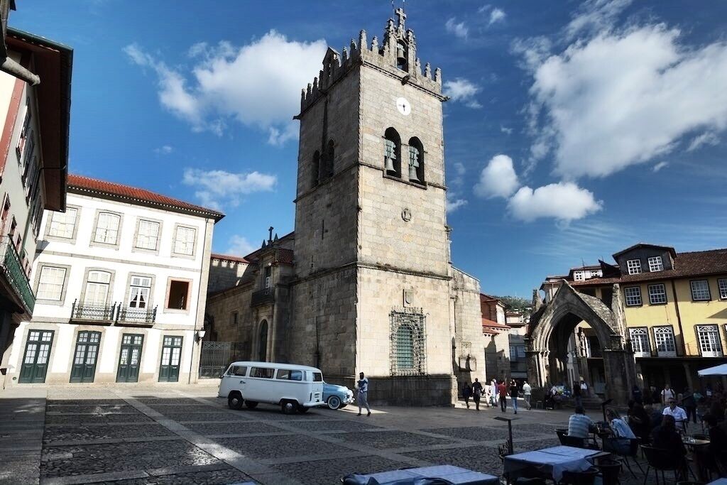 Igreja de Nossa Senhora da Oliveira is a collegiate church in Guimarães, Portugal. It is classified as a National Monument.  Iconic carvings and art found within this intimate and beautiful Church, with a Romanesque arched nave. Situated on the Largo da Oliveira Square, this is all that remains of the Monastery that the Castelo de Guimaraes was built to defend. The current church's cornerstone was laid 1/1/1384. The bell tower is in the Manueline style, and the Gothic Padrao do Salado Shrine presides over its entrance