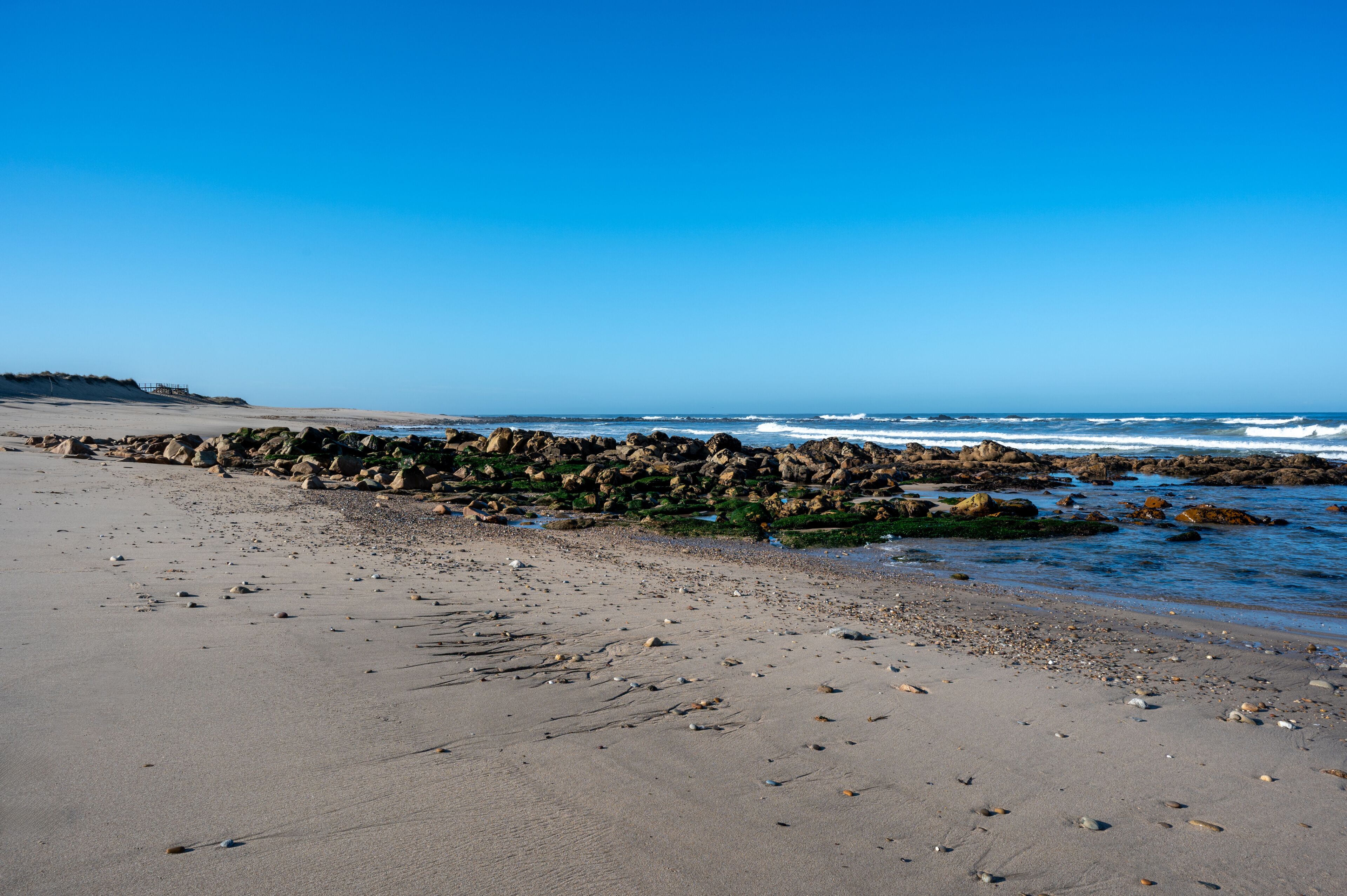 A rocky shoreline with waves crashing onto the beach.