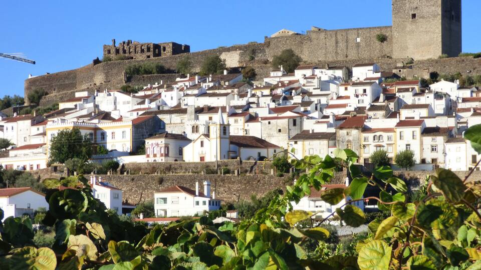 A hillside town with historic stone walls and white buildings.