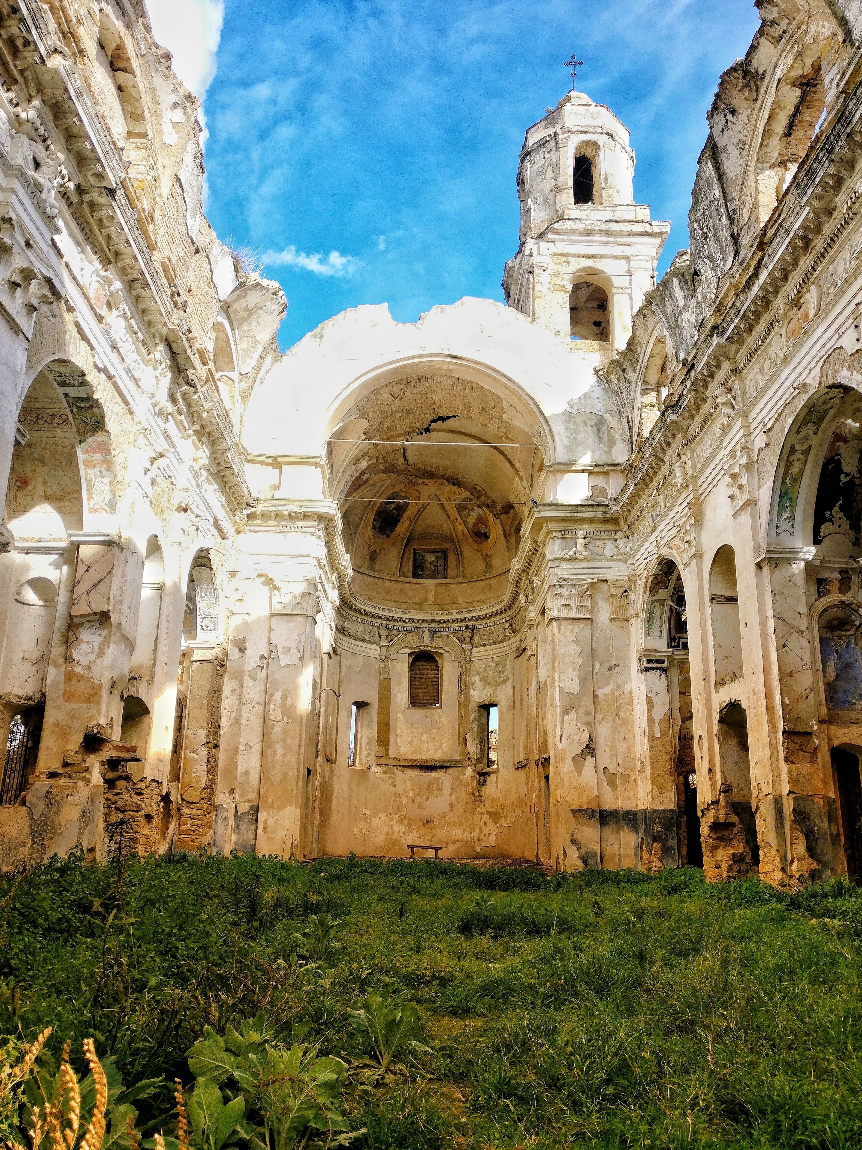 An ancient, dilapidated building with a large dome and bell tower.