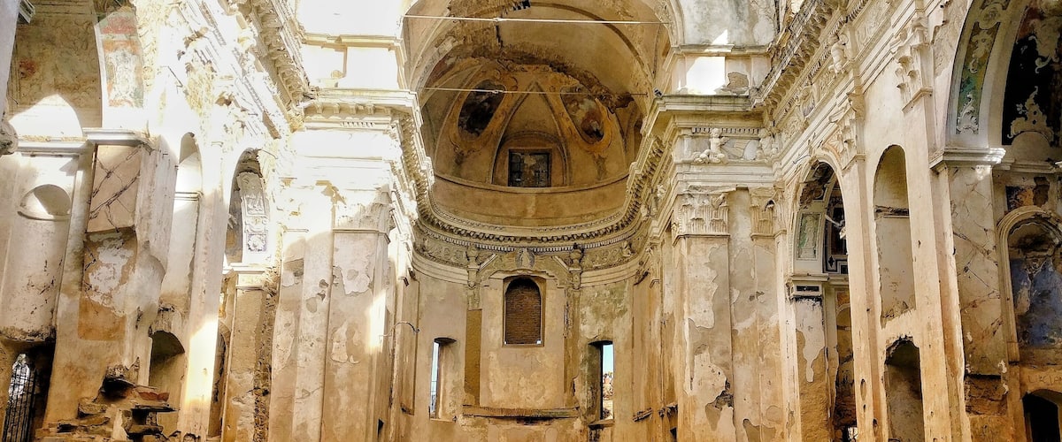 An ancient, dilapidated building with a large dome and bell tower.