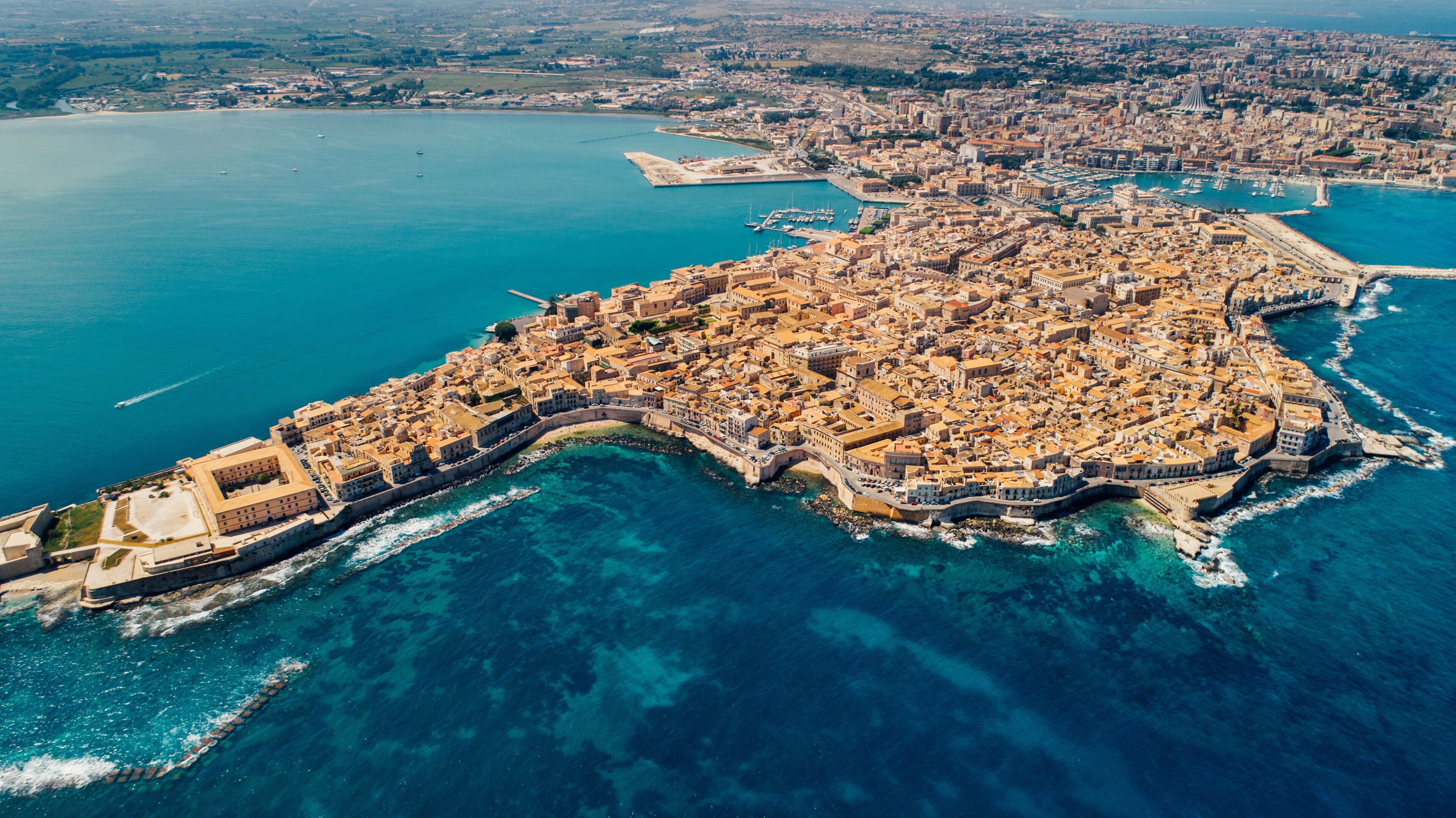 Aerial panoramic view of Ortigia island,old town of Syracuse.Small island on Sicily,Italy.Sicilian vacation,charming Italian experience.Beautiful seaside landscape