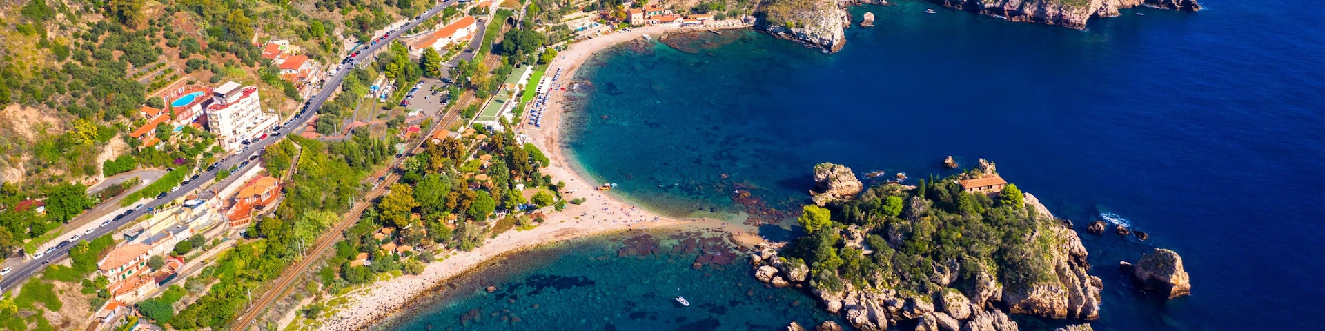 Aerial view of Isola Bella in Taormina, Sicily, Italy. Isola Bella is small island near Taormina, Sicily, Italy. Narrow path connects island to mainland Taormina beach in azure waters of Ionian Sea.