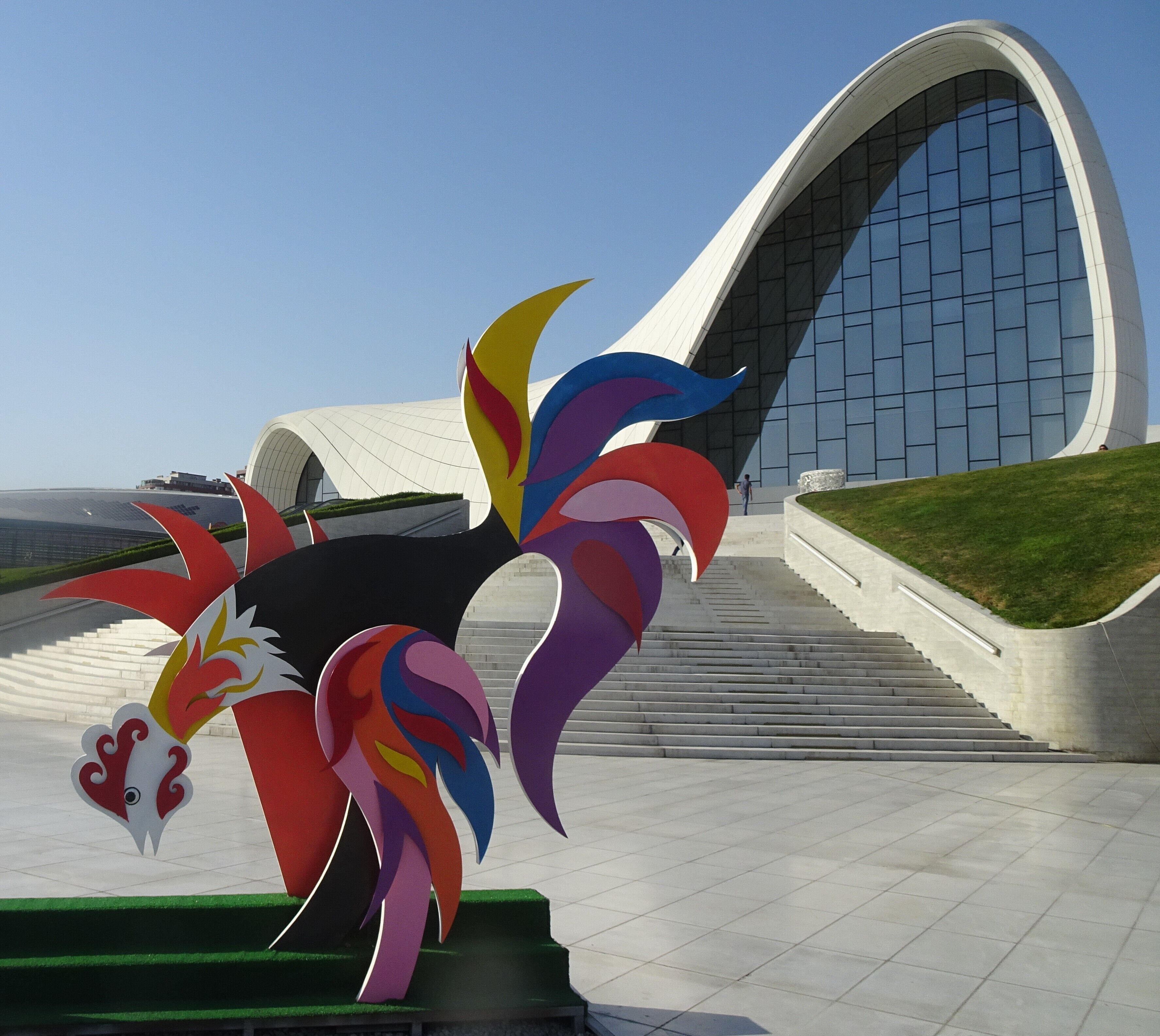 Modern Art in front of the Heydar Aliyev Centre.
The Centre, built in 2012 under the guidance of the legendary Iraqi-British architect Zaha Hadid (1950-2016) is famous for its smooth forms without sharp corners. Extending on eight floor levels, the centre accommodates an auditorium, temporary exhibition spaces, a conference centre and a museum. #Culture  #Trovember