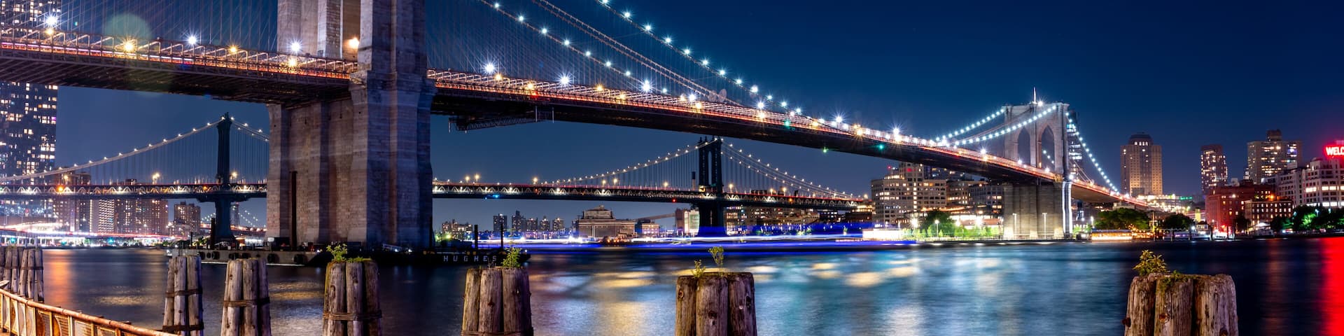 Wide Angle Panorama of the Brooklyn Bridge At Night With Clear Skies