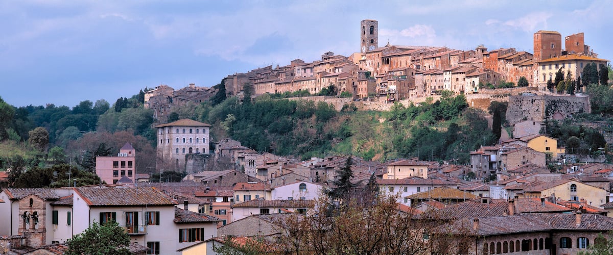 A historic town with a prominent hilltop church and a bell tower.