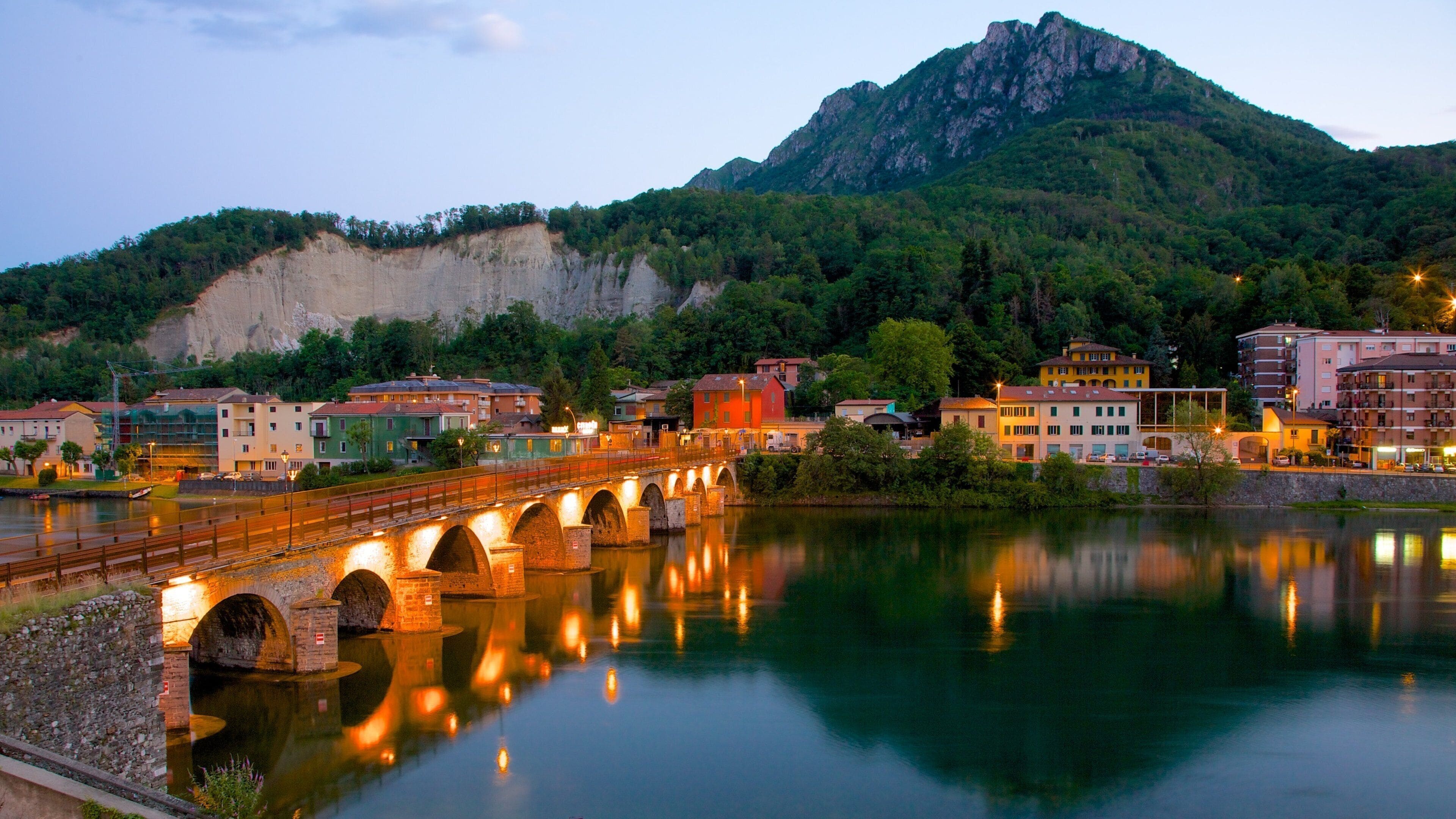 Lecco que incluye montañas, un puente y escenas nocturnas