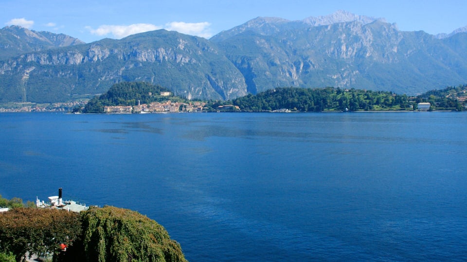 A lake with a town on the opposite shore, surrounded by mountains.