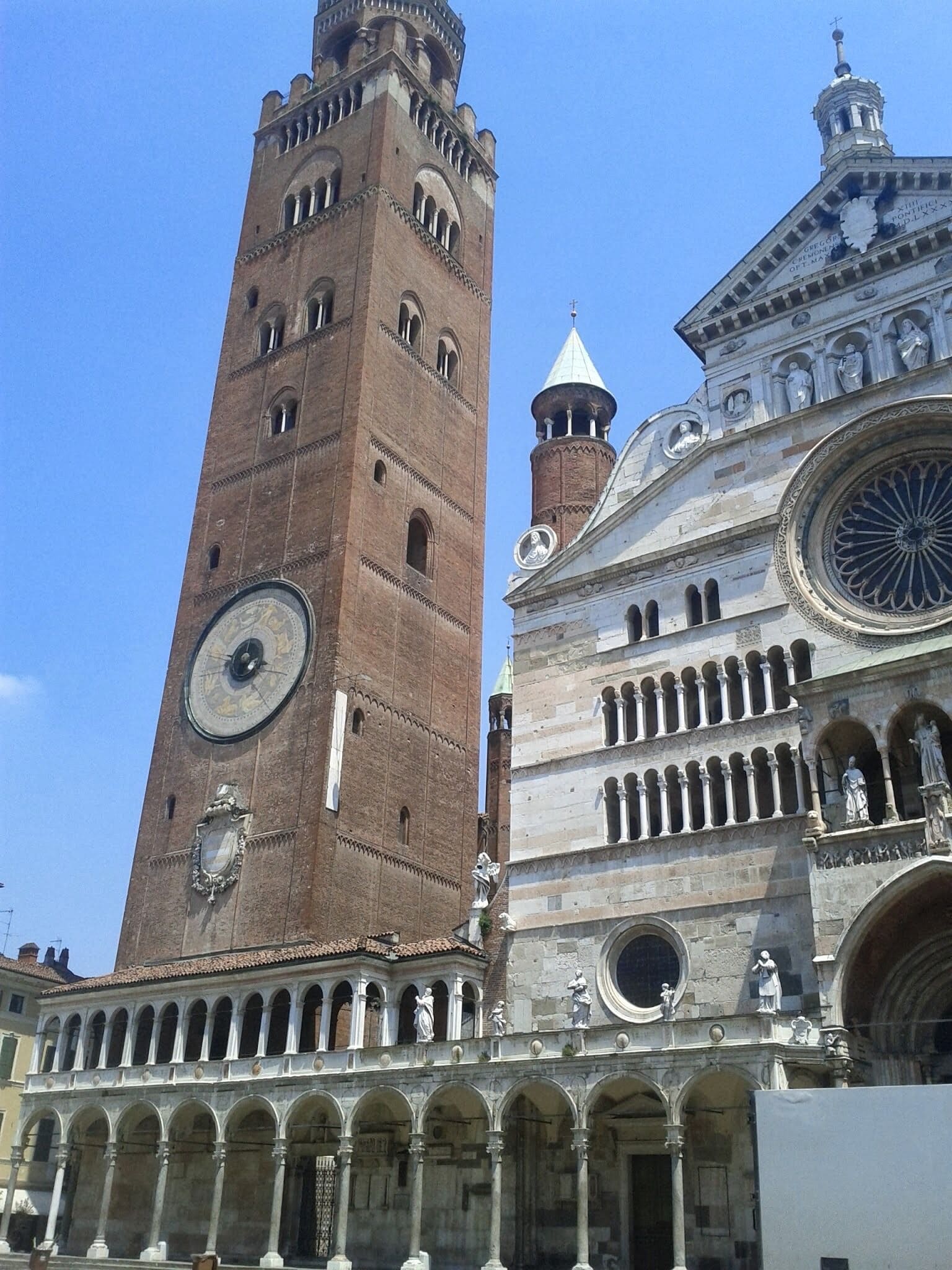 A historic building with a tall clock tower and a dome with statues.