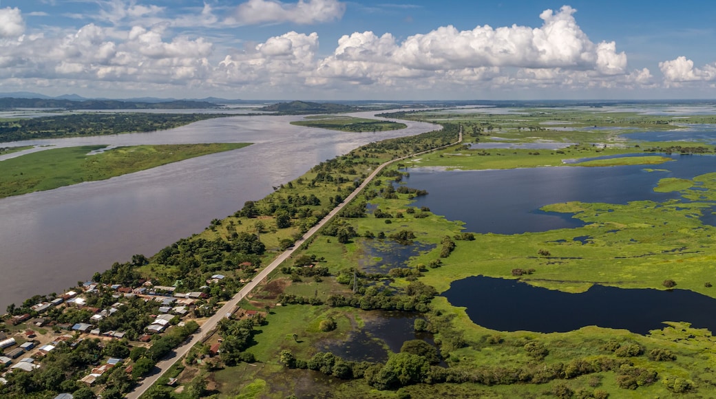 A river winding through a green landscape with a small town along its banks.