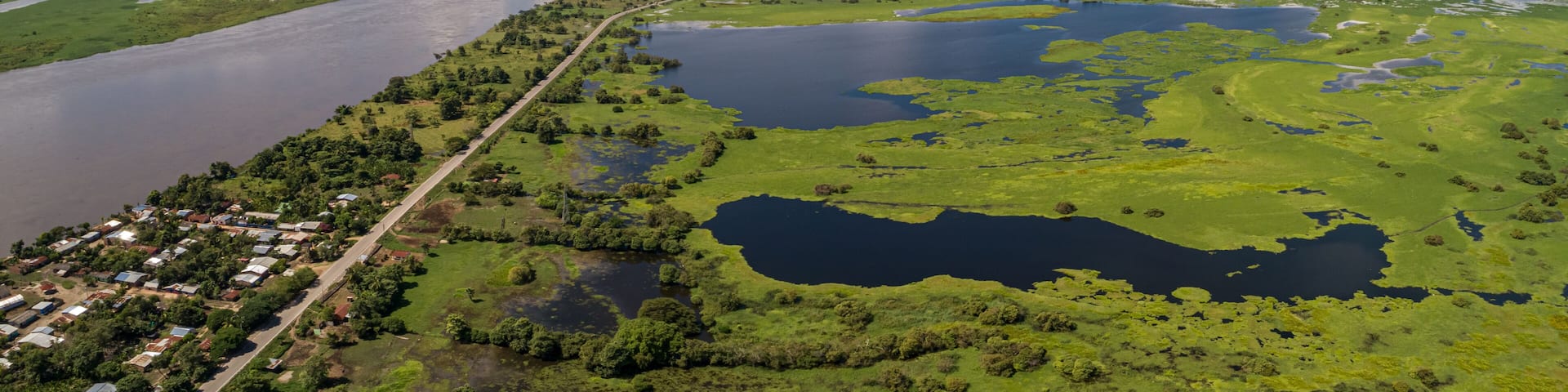 A river winding through a green landscape with a small town along its banks.