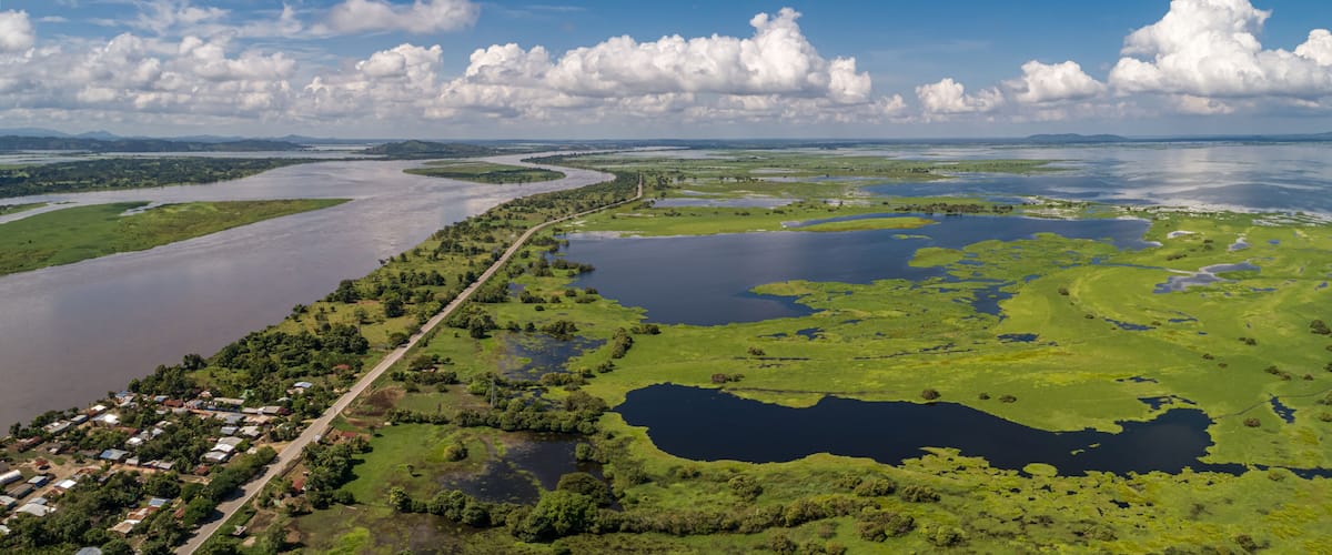 Panoramic aerial view of impressive Magdalena River landscape with blue sky, white clouds and village on a sunny day