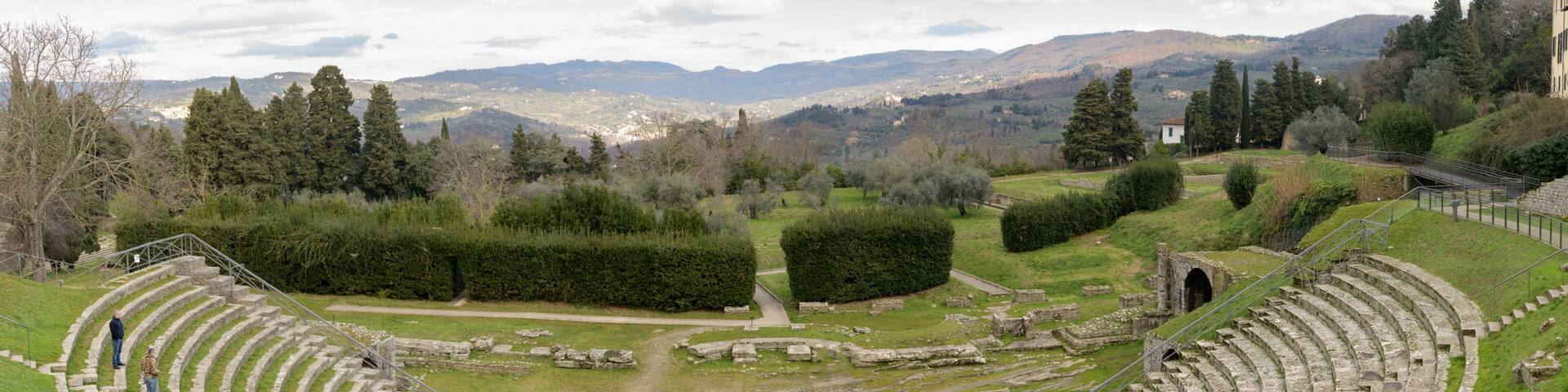 Ruins of the ancient Roman theater in Fiesole, near Florence, Italy, built in the 1st century BC, with semicircular seating and scenic backdrop.