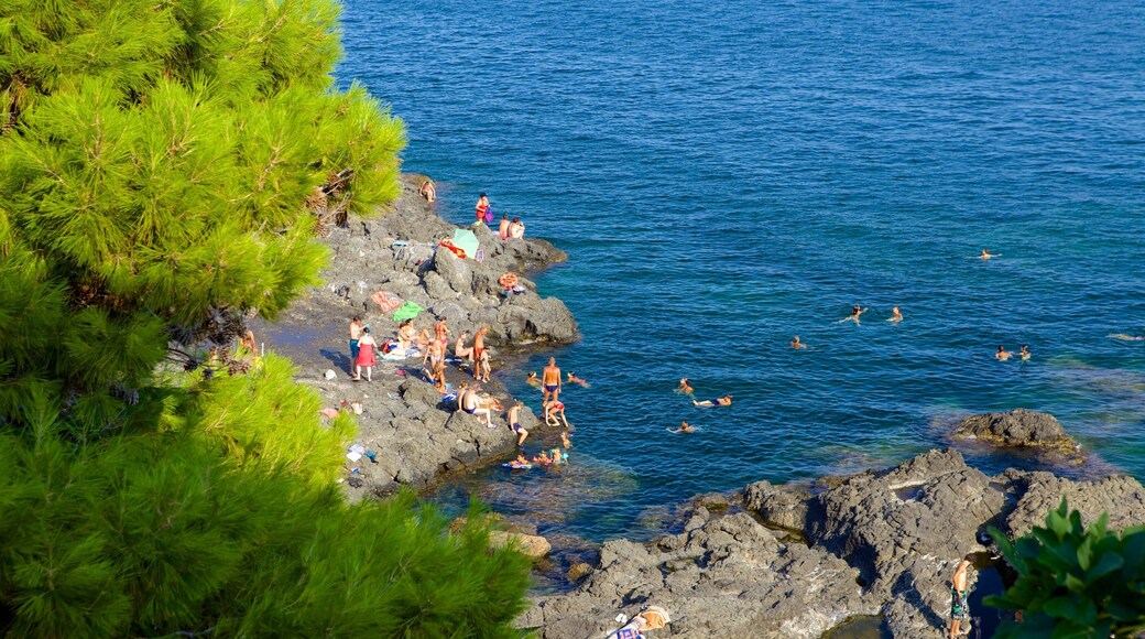 Aci Castello featuring rocky coastline and swimming