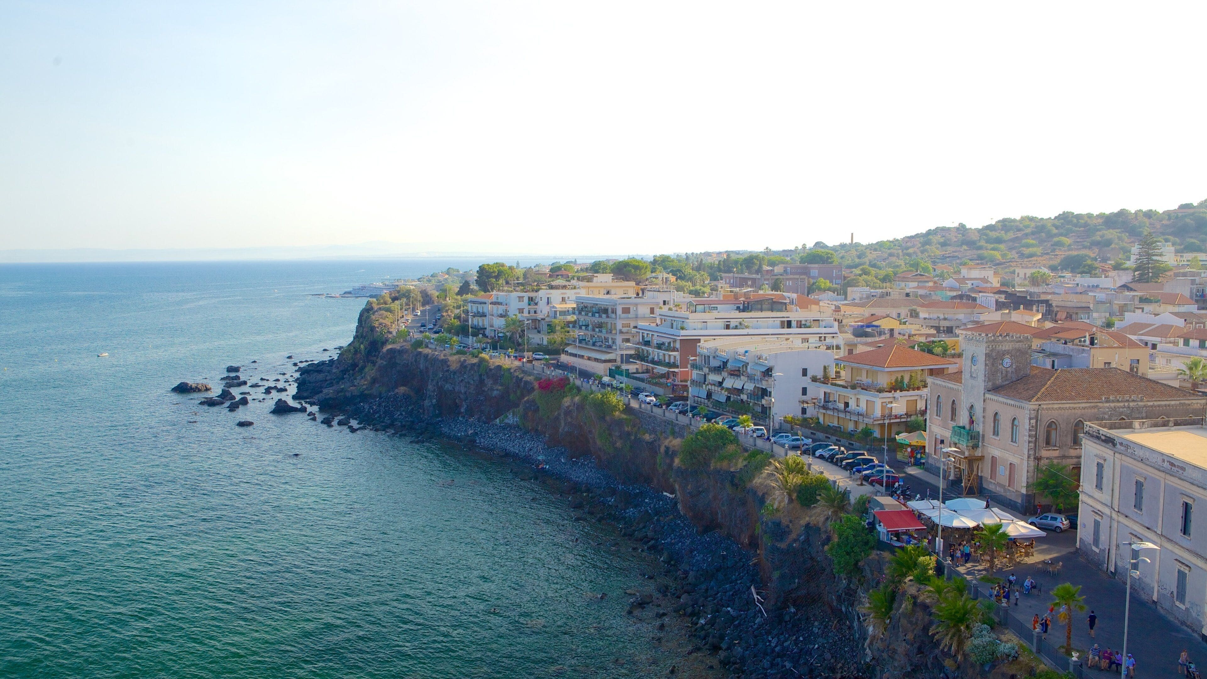 Aci Castello featuring a coastal town and rugged coastline