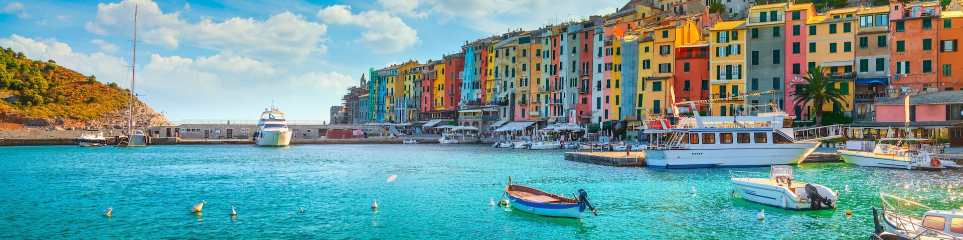 A coastal town with colorful buildings, a prominent church, and boats in the water.