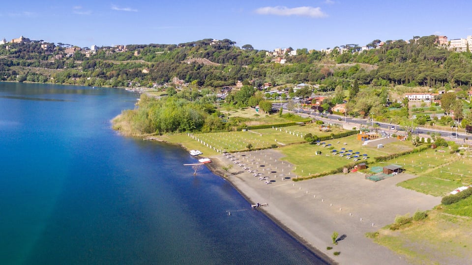 A coastal town with a beach, a marina, and a hilltop castle.