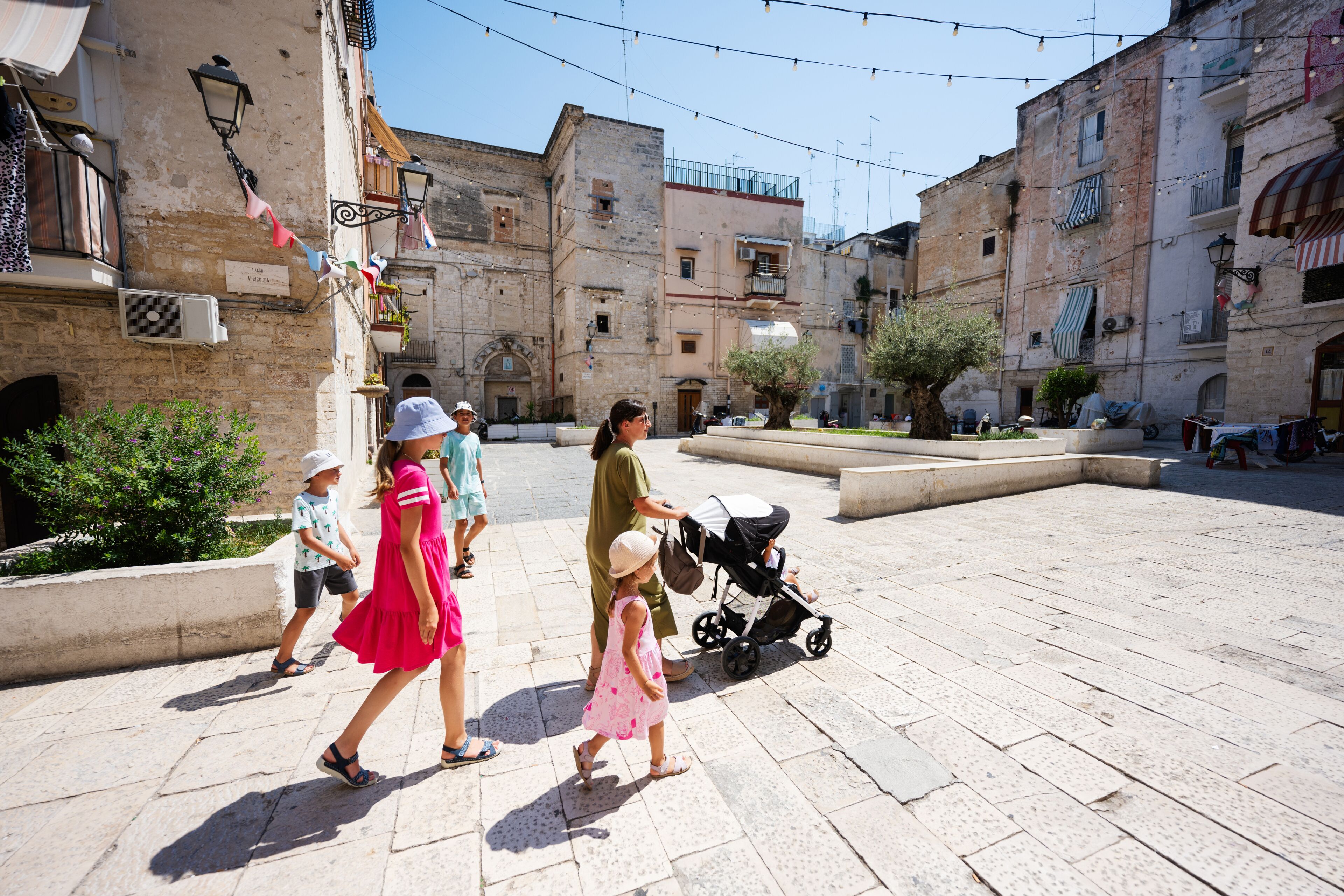 Family of tourists waking in streets Bari, Puglia, South Italy.