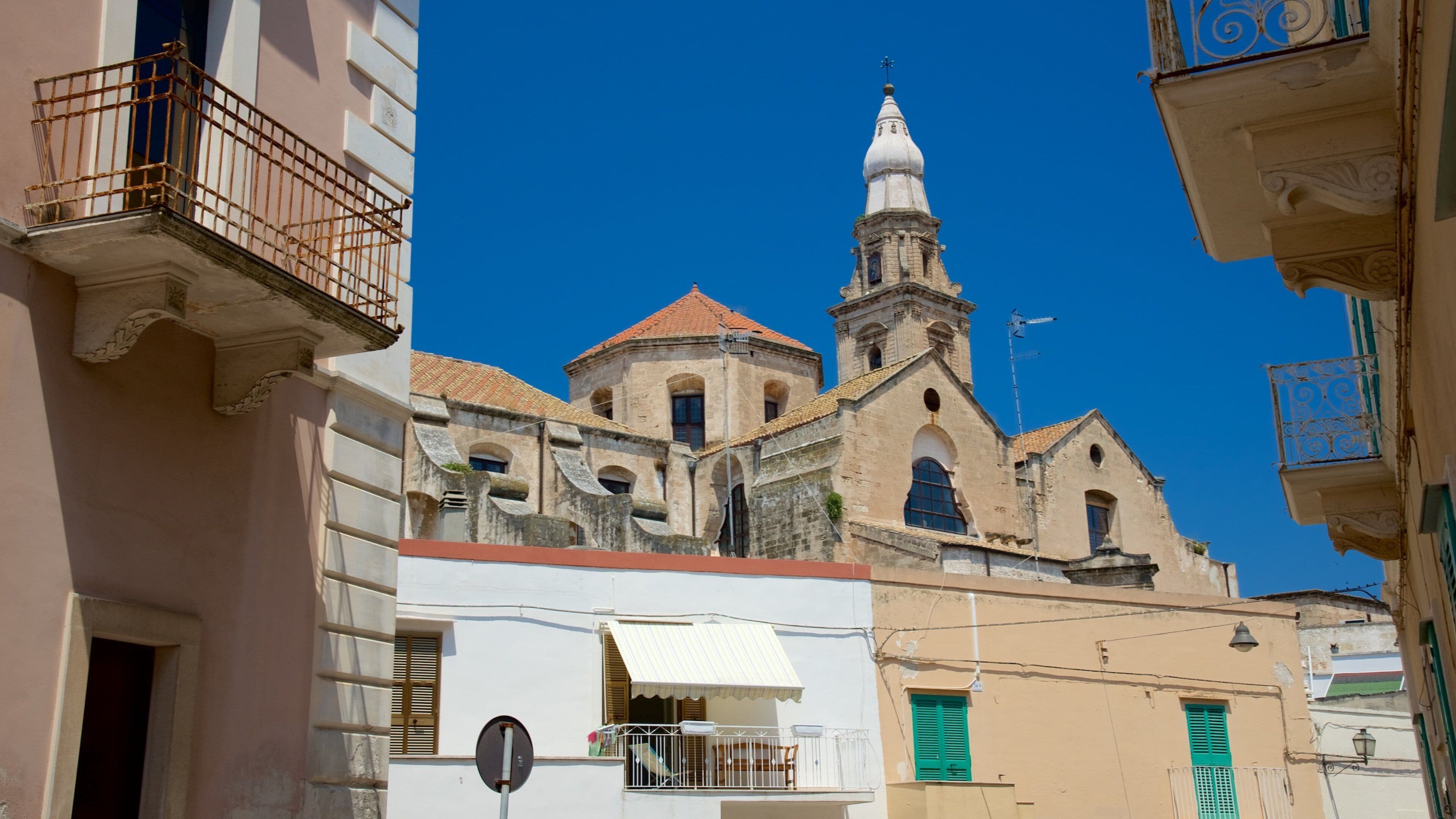 Uma igreja histórica com uma torre de sino e fachada branca.
