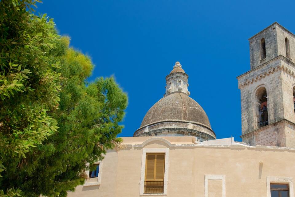 A church with a dome and bell tower under a clear blue sky.