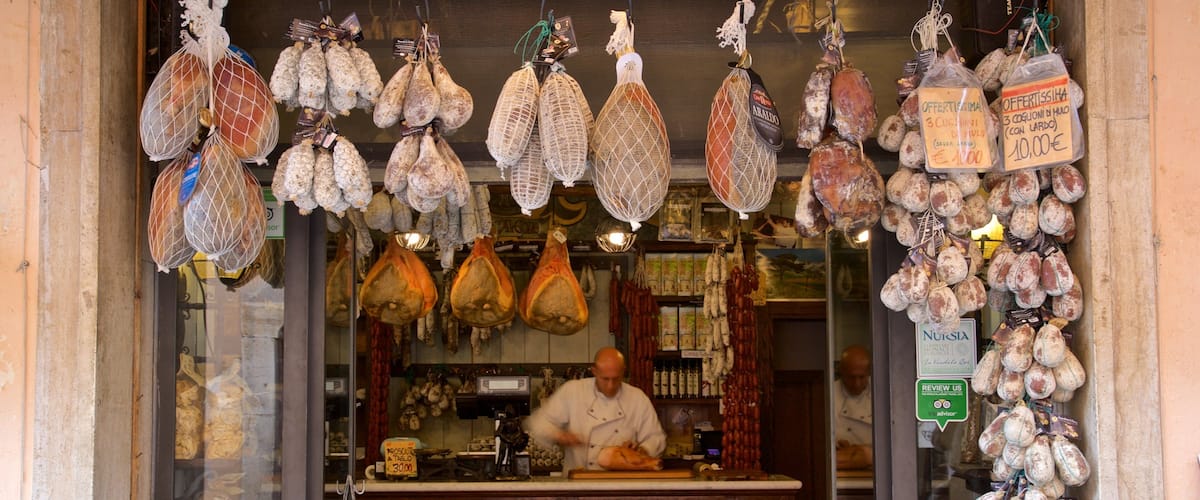 Ein Metzgerei mit verschiedenen Fleischsorten zum Verkauf, darunter Prosciutto und andere Wurstwaren.