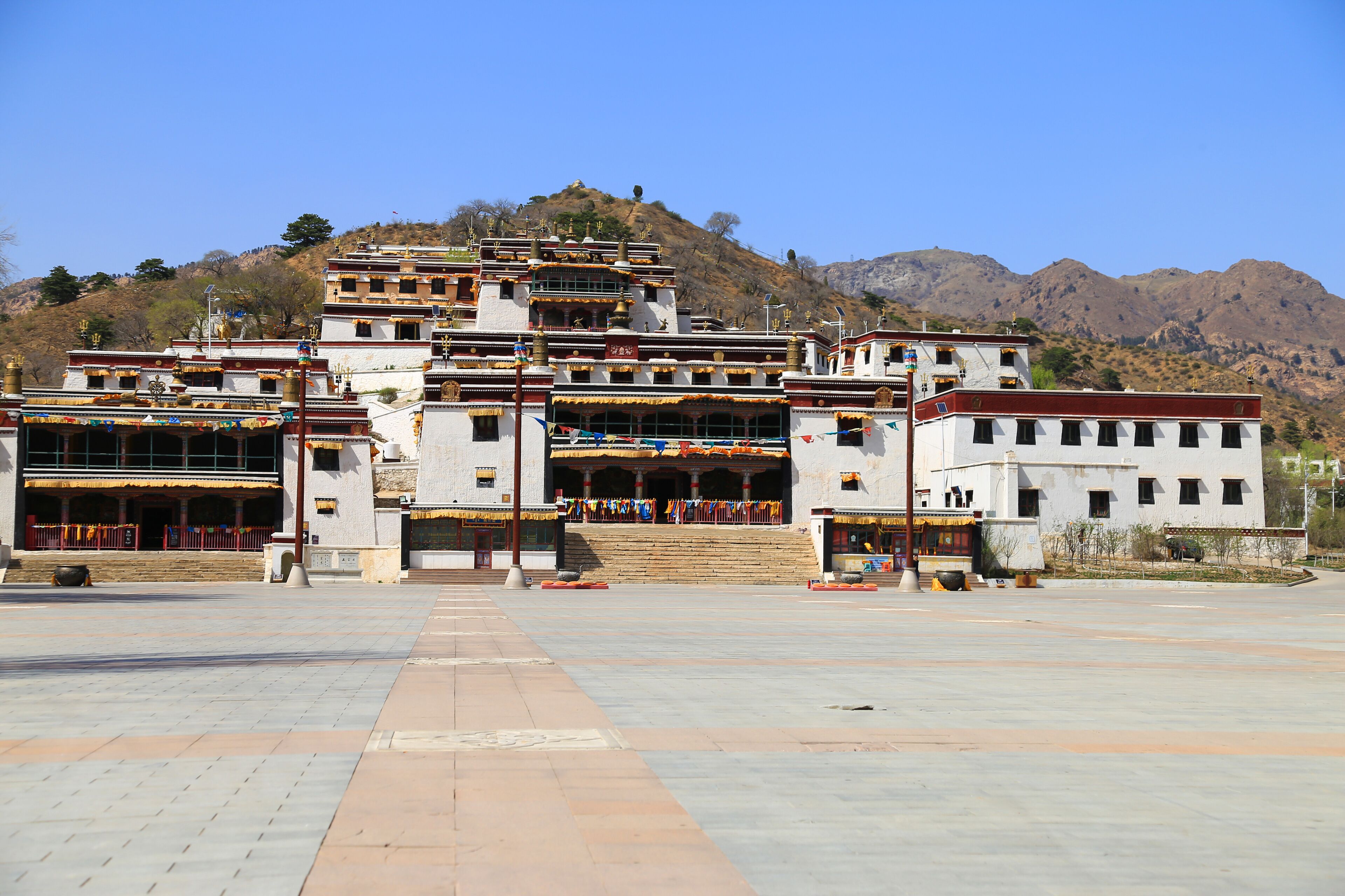 A multi-tiered temple complex with a mountainous backdrop.