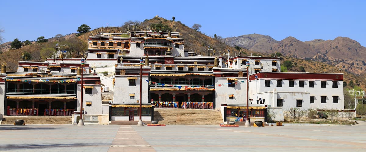 A multi-tiered temple complex with a mountainous backdrop.
