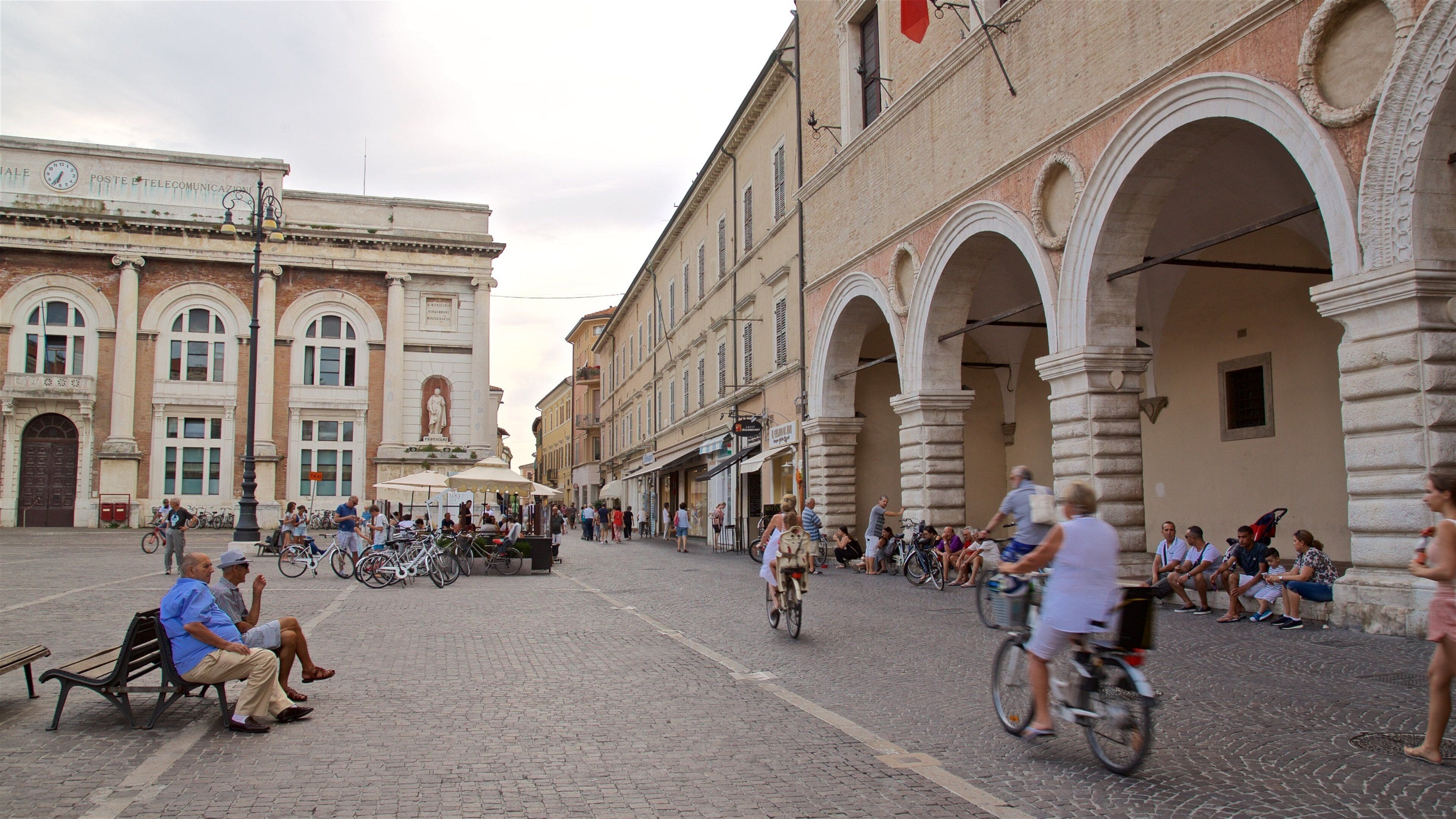 Pesaro caratteristiche di strade e piazza cosi come un piccolo gruppo di persone