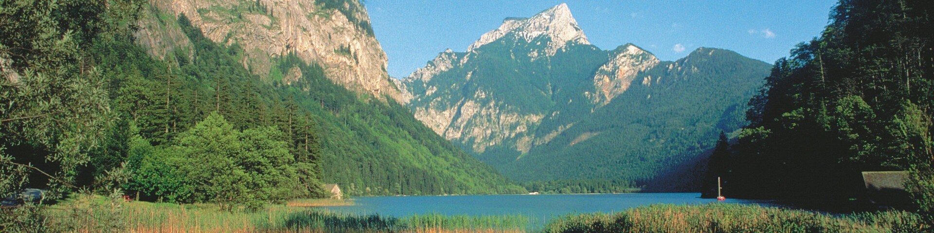 A lake surrounded by mountains and dense forests.