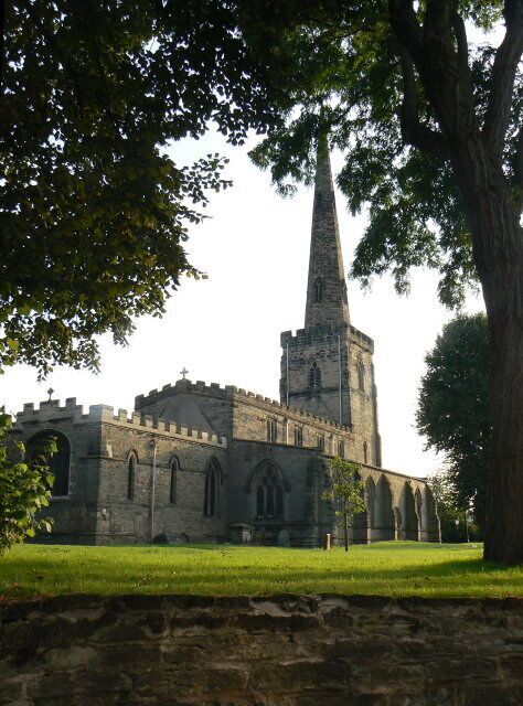 A historic church with a tall spire and arched windows.
