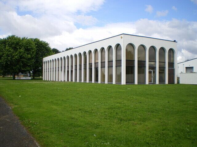 A modern building with a row of arched windows and a flat roof.