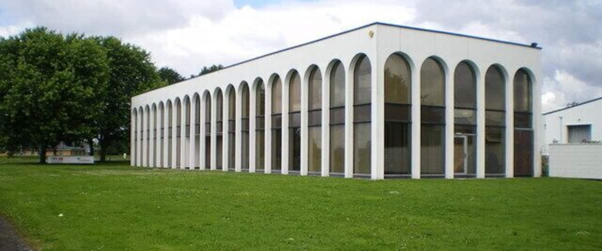 A modern building with a row of arched windows and a flat roof.