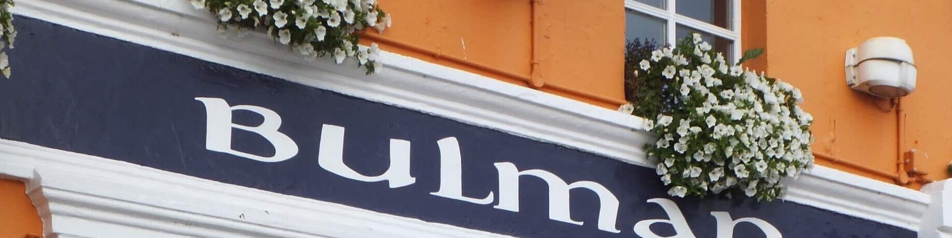 A building with a sign reading "Bulman" and a blue door.