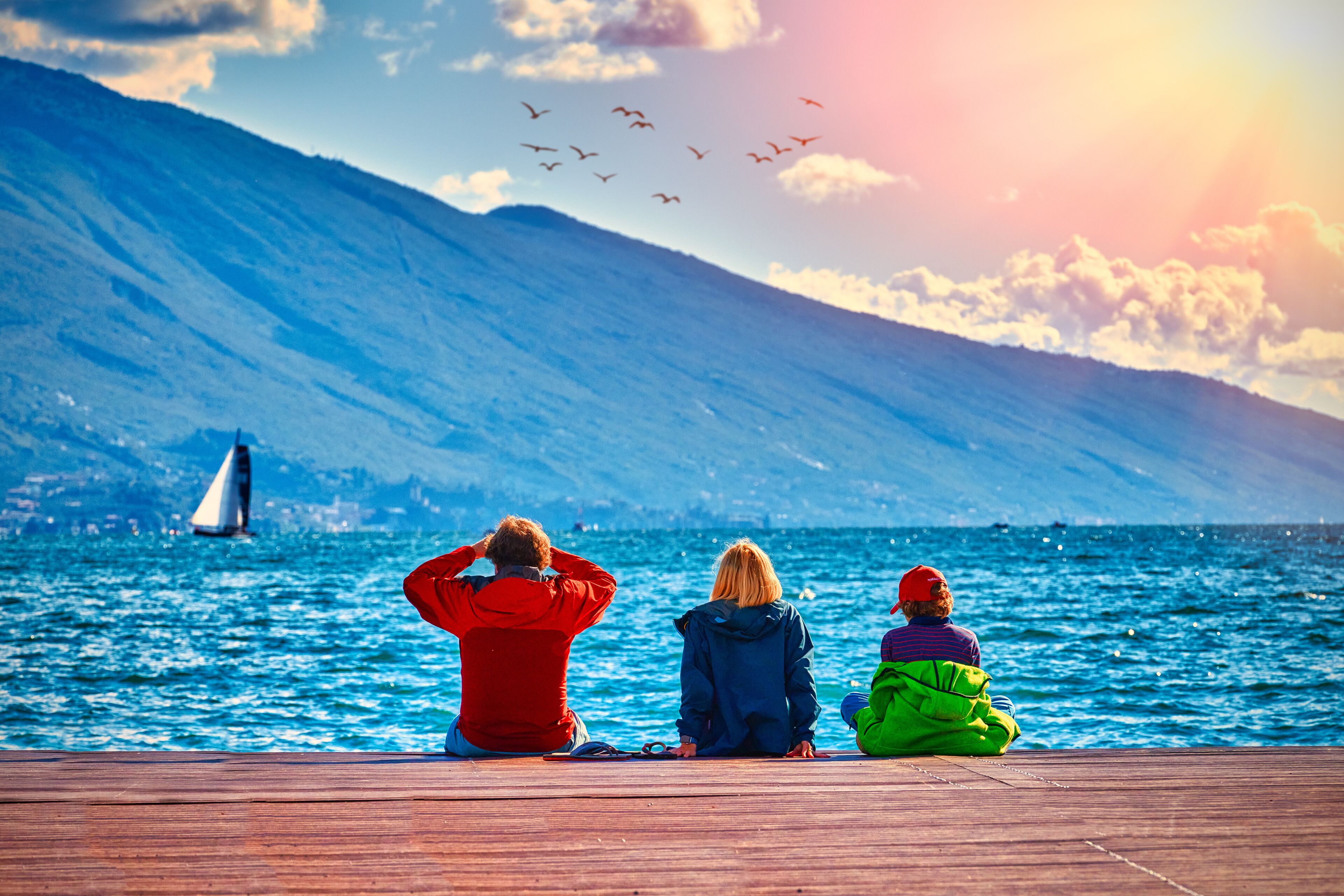 View of the beautiful Lake Garda surrounded by mountains, Scenic view of sunset at Lake Garda in the evening with the beautiful sunset colors, italy