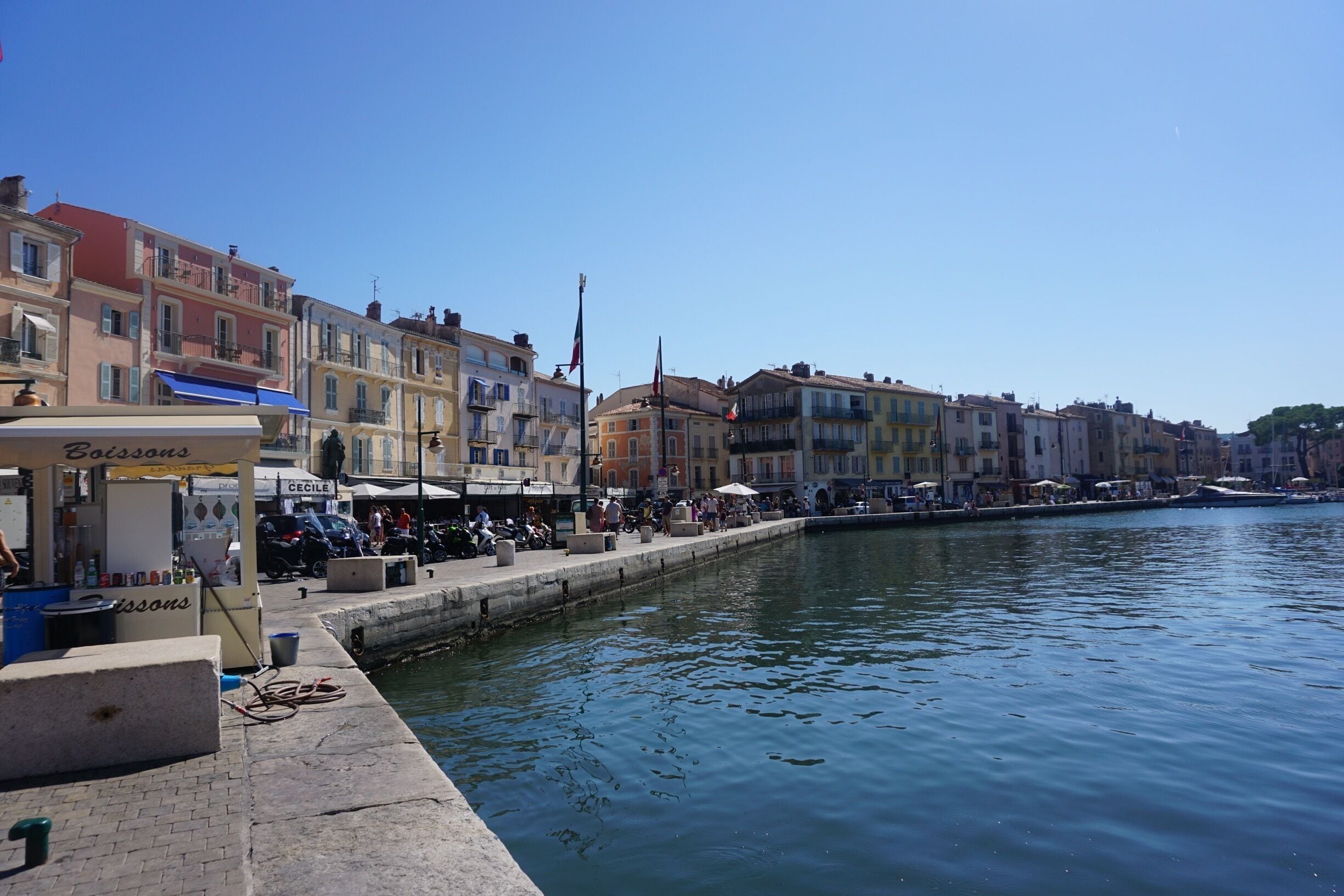 Un paseo marítimo con edificios coloridos, un canal y un puesto de comida.