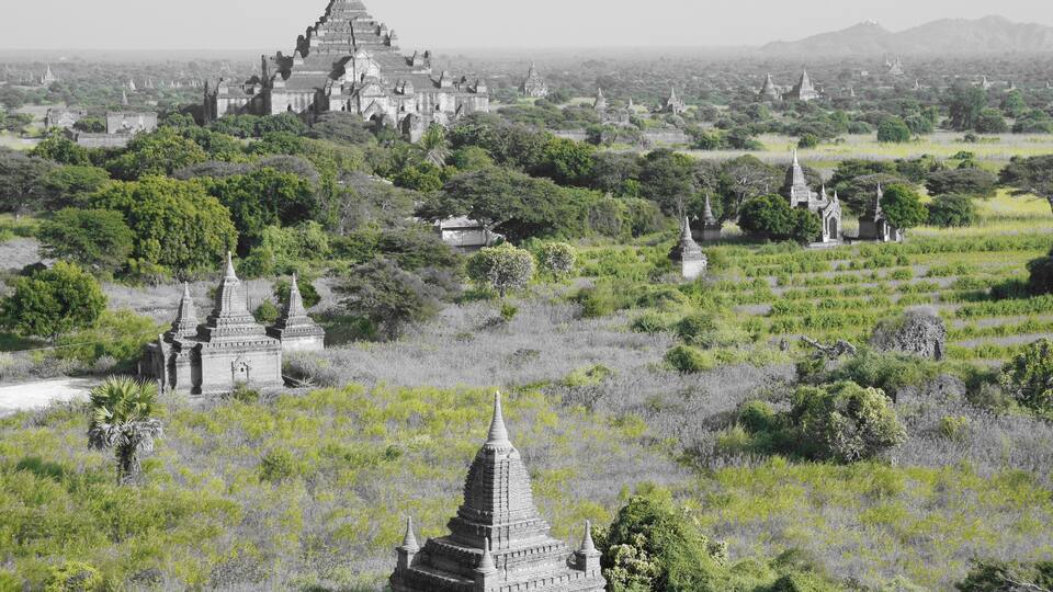 A landscape with ancient temples amidst lush greenery.