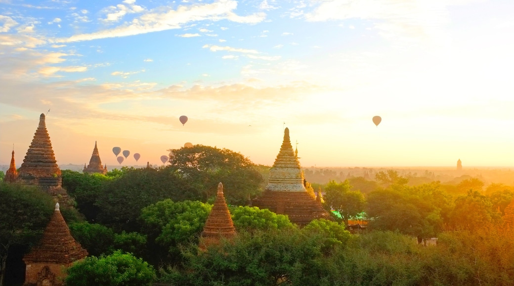 Sunrise in Bagan Archeologial Zone, Myanmar top view with hot air ballooons flying on a horizont. View from a pagoda rooftop