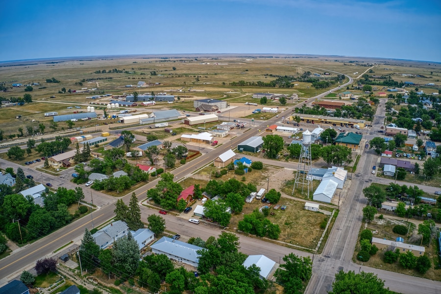 An aerial view of a small town with a mix of industrial buildings, residential houses, and green spaces.